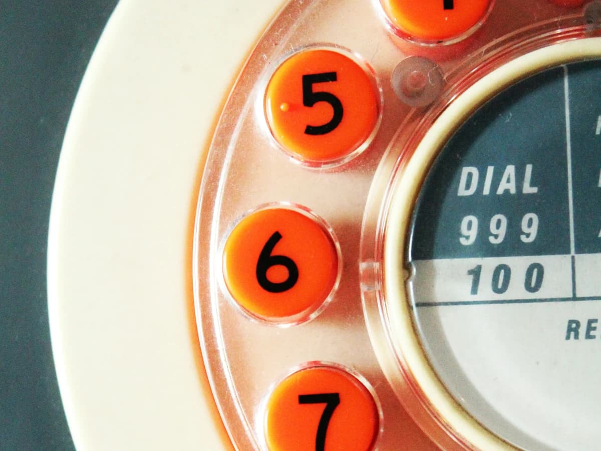 Close-up of a rotary telephone dial reading DIAL 999, the number also used for emergencies in Qatar