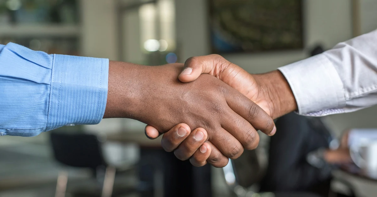Two professionals shaking hands after agreeing on a new job offer