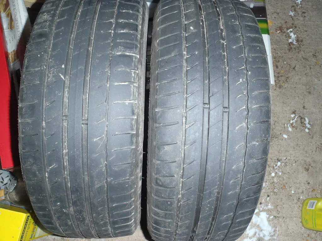 Two part-worn car tyres side by side, one with noticeably shallower tread than the other