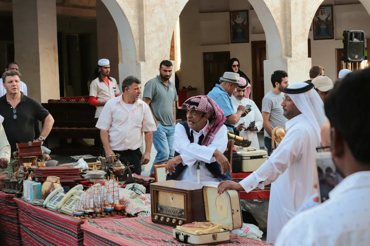 Traders and shoppers at an outdoor market stall in Souq Waqif, Doha