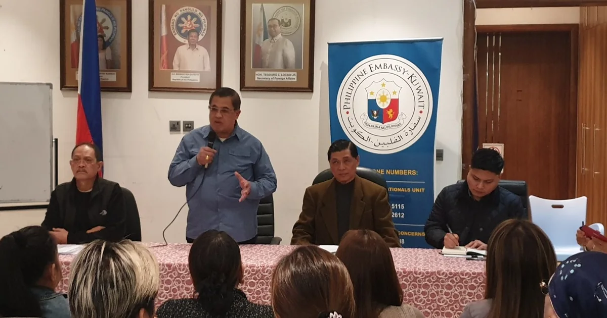 Philippine officials meeting Filipino community members at an embassy briefing in the Gulf, with Assistance to Nationals hotline numbers displayed