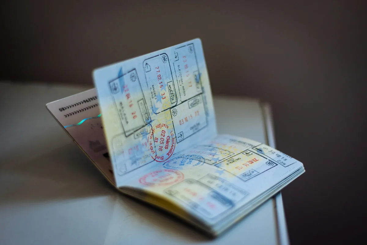 An open passport showing visa and entry stamps, illustrating the kind of identity document an exchange house asks to see at registration.