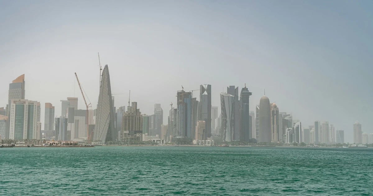 Doha West Bay skyline seen across the bay through a pale haze of dust